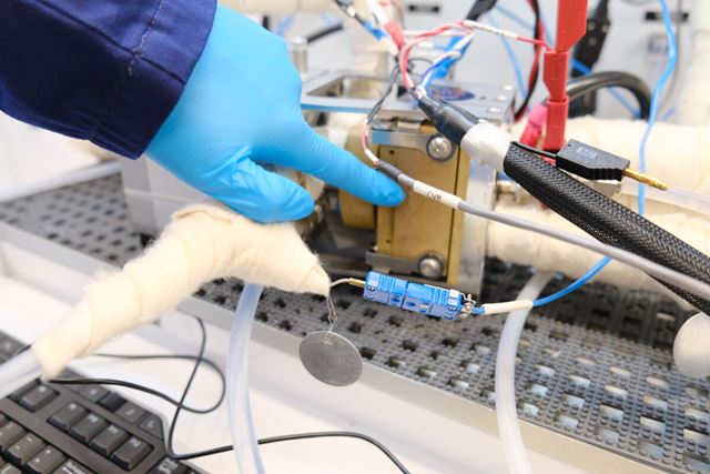 Patrick peker på hvor membranen og katalysatoren går inn i brenselcellen på Hydrogenlaboratoriet til SINTEF. 