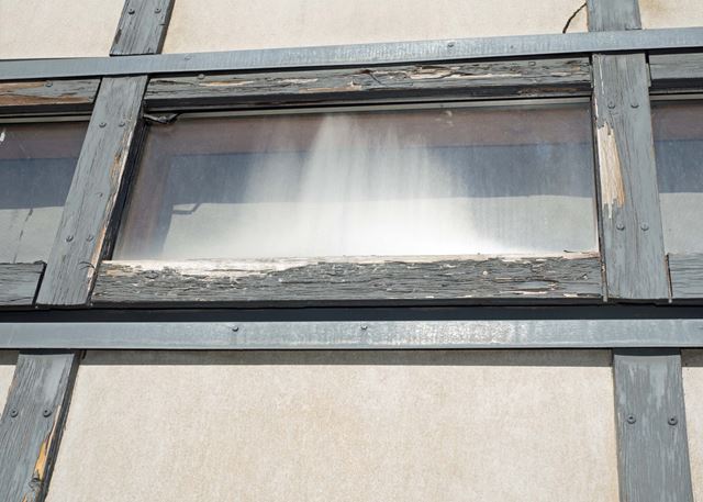 Et relativt nytt bygg har tydelige skader på vinduskarmene. 