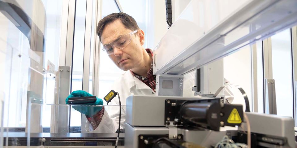 Researcher and biochemist Torkild Visnes in his lab at SINTEF. He is currently working to establish a similar biomedical research group focusing on drug development at SINTEF. Here pictured in front of a biological screening device. Photo: SINTEF/Thor Nielsen.