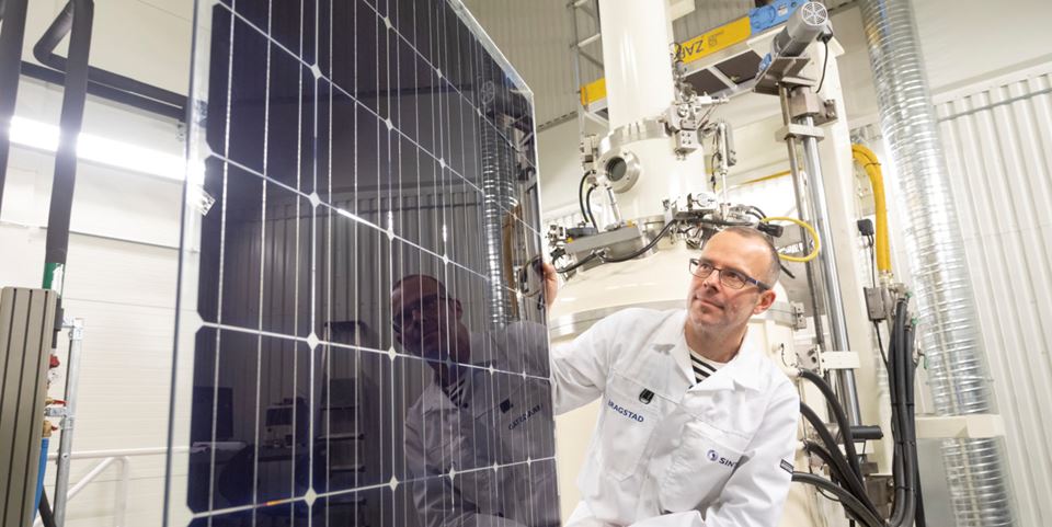 Researcher Martin Bellmann demonstrating the solar panel that can achieve maximum output because it has been fitted with its own cooling system. The panel was developed at SINTEF’s solar cell lab. Photo: Thor Nielsen.
