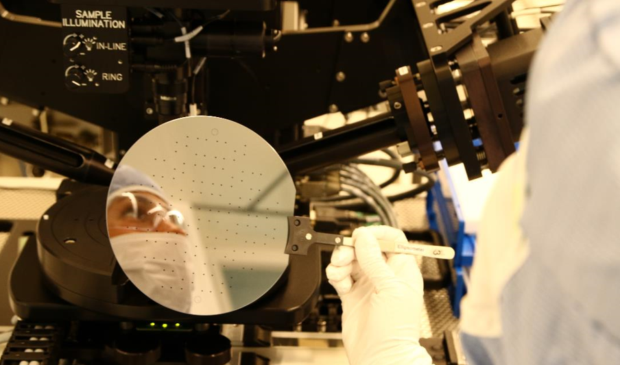 Researcher and blog author Elizaveta Vereshchagina in the laboratory. Microfluidics technology has a variety of applications, including DNA analysis and organ-on-a-chip. The photo shows a 6-inch silicon wafer during processing in cleanroom. The dots are inlets to and outlets from the microfluidic channel.