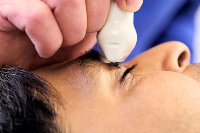 The ultrasound probe are measuring the optic nerve on a patient