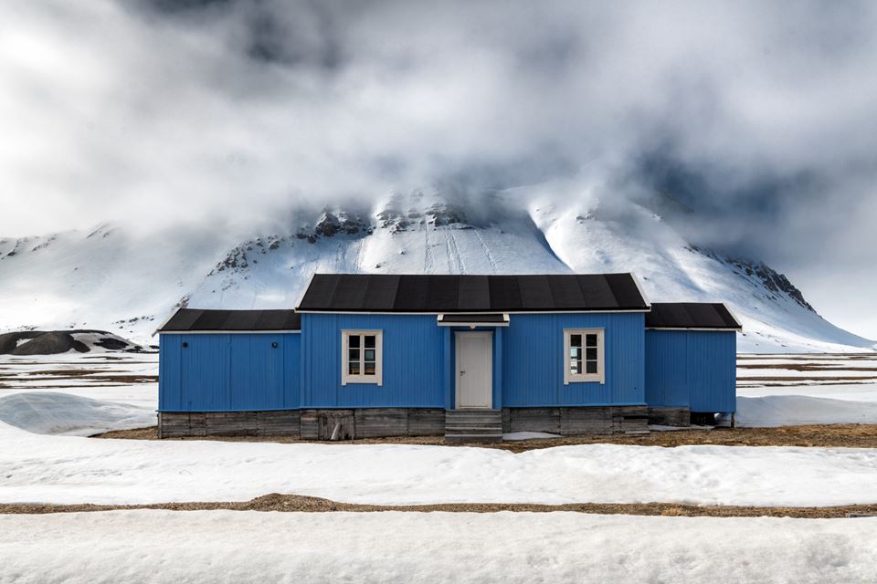 Old, blue, and threatened by climate change. Timber foundations of buildings and structures are affected by rot decay and melting permafrost at Svalbard. Photo: Shutterstock