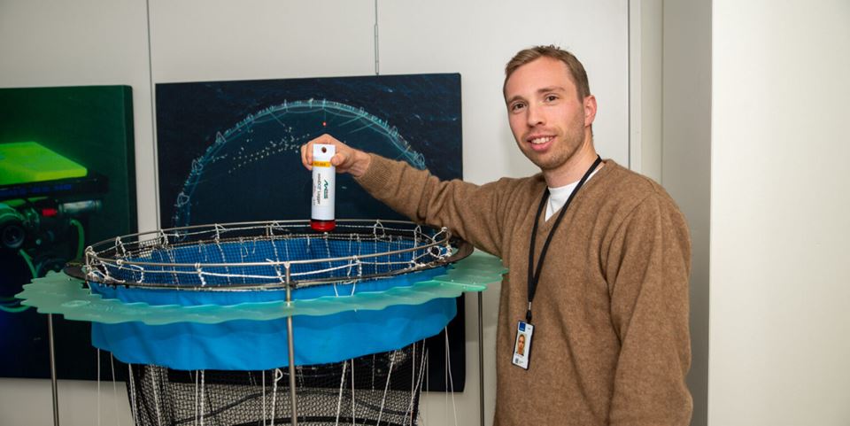 Hans Tobias Slette at SINTEF says that now that the fish farming sector is looking to operate with bigger facilities and more fish in each net pen, reliable calculations of oxygen availability are more important than ever. Here we see him demonstrating a so-called miniDOT, which is a device for  measuring oxygen. Photo: Daniel Gløsen