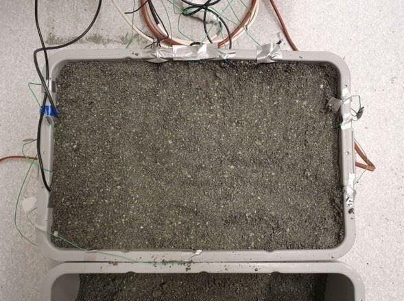 Testing sensors in cable sand. When the power cables overheat, the sand dries out and turns into an insulating “thermos.” Controlling the evaporation and inflow of moisture is therefore critical. Photo: SINTEF